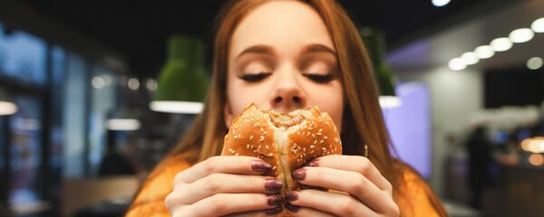 Devojka jede burger - Sputnik Srbija