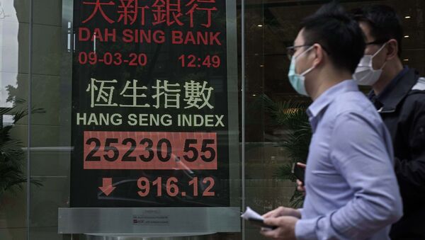 Човек са маском пролази поред берзанског дисплеја испред банке у Хонгконгу - Sputnik Србија