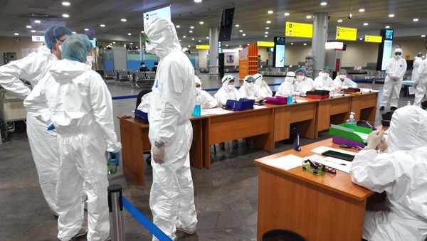 Medicinski radnici u zaštitnim odelima na aerodromu Šeremetjevo u Moskvi - Sputnik Srbija