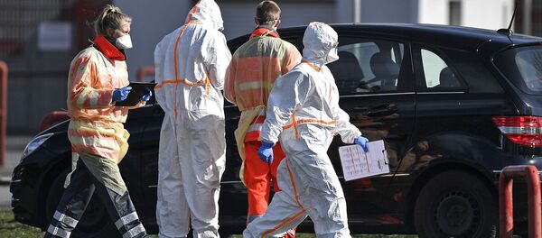 Vatrogasci i radnici Crvenog krsta uzimaju uzorke za test na koronavirus od vozača automobila u Nemačkoj Vatrogasci i radnici Crvenog krsta uzimaju uzorke za test na koronavirus od vozača automobila u Nemačkoj - Sputnik Srbija