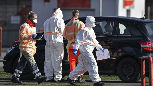 Vatrogasci i radnici Crvenog krsta uzimaju uzorke za test na koronavirus od vozača automobila u Nemačkoj - Sputnik Srbija