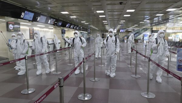Radnici u zaštitnim odelima dezinfikuju hodnik na aerodromu u Daeguu u Južnoj Koreji - Sputnik Srbija