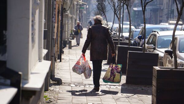 Žena sa punim torbama nakon kupovine usred epidemije koronavirusa - Sputnik Srbija
