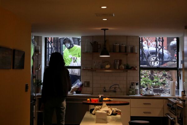Њујорчанка Наоми Хасбрук преузима храну од достављача док ради од куће. - Sputnik Србија
