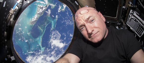 Астронаут НАСА Скот Кели у специјалном модулу Међународне свемирске станице са којег се види Земља Астронаут НАСА Скот Кели у специјалном модулу Међународне свемирске станице са којег се види Земља - Sputnik Србија