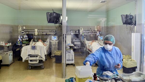 Лекар у заштитном оделу поред пацијената са вирусом корона КОВИД-19 у болници у Италији - Sputnik Србија