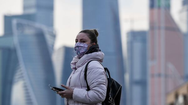 Devojka sa maskom pored trgovinskog centra u Moskvi Devojka sa maskom pored trgovinskog centra u Moskvi - Sputnik Srbija