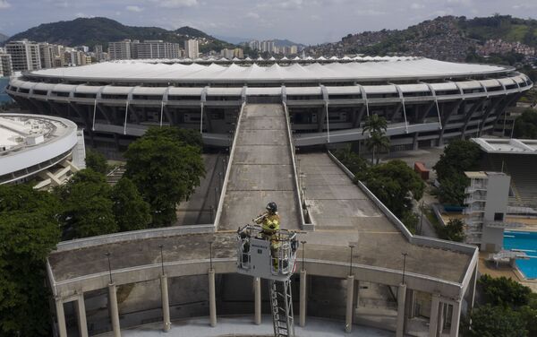 Brazilski vatrogasac Elijelson Silva svira trubu sa 50 metara visine, dok se u pozadini vidi stadion Marakana - Sputnik Srbija