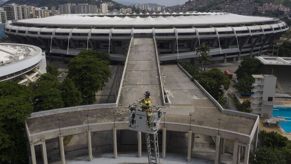 Brazilski vatrogasac Elijelson Silva svira trubu sa 50 metara visine, dok se u pozadini vidi stadion Marakana - Sputnik Srbija
