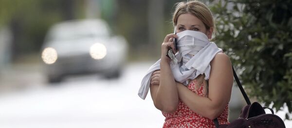 Žena čeka u redu da uđe u trgovinu i razgovara mobilnim telefonom sa košuljom omotanom oko lica, Florida. Žena čeka u redu da uđe u trgovinu i razgovara mobilnim telefonom sa košuljom omotanom oko lica, Florida. - Sputnik Srbija
