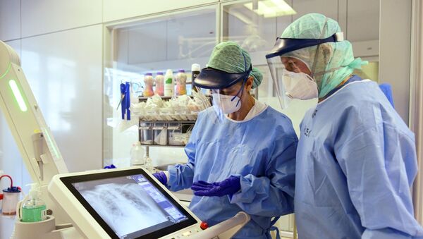 Запослени клинике у Бергаму у заштитним маскама гледају рендгенски снимак плућа пацијента који има вирус корона - Sputnik Србија