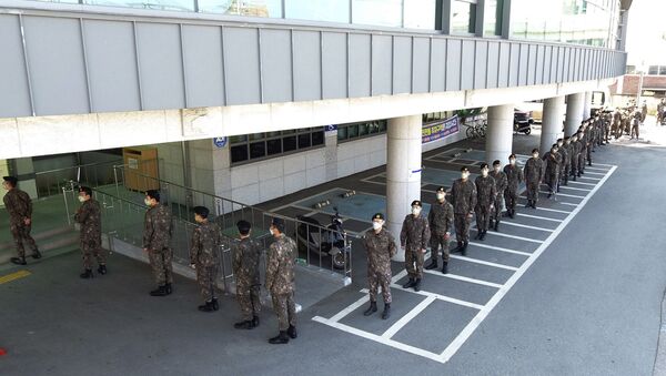 Vojnici sa maskama na licu stoje u redu za glasanje na izborima u Južnoj Koreji - Sputnik Srbija