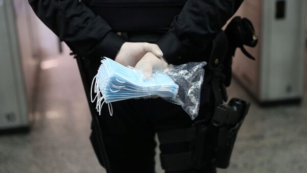 Полицајац држи заштитне маске за лице  - Sputnik Србија