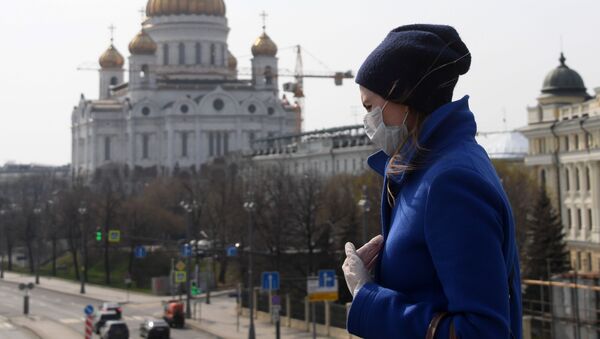 Девојка у заштитној маски и рукавицама испред Храма Христа Спаситеља у Москви - Sputnik Србија