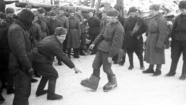 Sovjetski vojnik pokazuje saborcima „nemačke valjenke“ - Sputnik Srbija