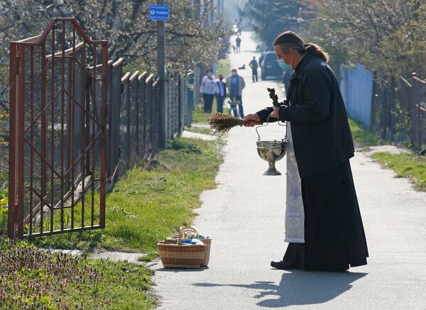 Sveštenik Pravoslavne crkve u Ukrajini tokom ceremonije blagoslova uskršnjih kolača i jaja u selu blizu Kijeva. - Sputnik Srbija
