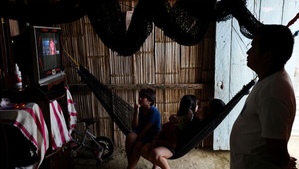Đina i njen suprug Viktor koji poslednjih nedelja nisu mogli da rade zbog mera koje je država preduzela protiv virusa korona, sa decom gledaju TV u Ekvadoru. - Sputnik Srbija