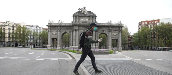 Čovek sa zaštitnom maskom i rukavicama prolazi pored pustog trga u Madridu - Sputnik Srbija