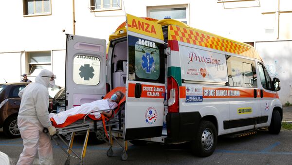 Medicinski radnici unose pacijenta u vozilo hitne pomoći u Rimu - Sputnik Srbija