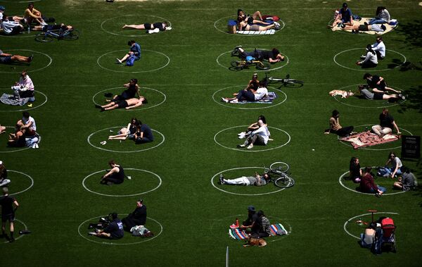 Људи практикују друштвено дистанцирање седећи у означеним белим круговима у Домино парку током пандемије ковида 19, 17. маја 2020. у Бруклину у Њујорку. - Sputnik Србија