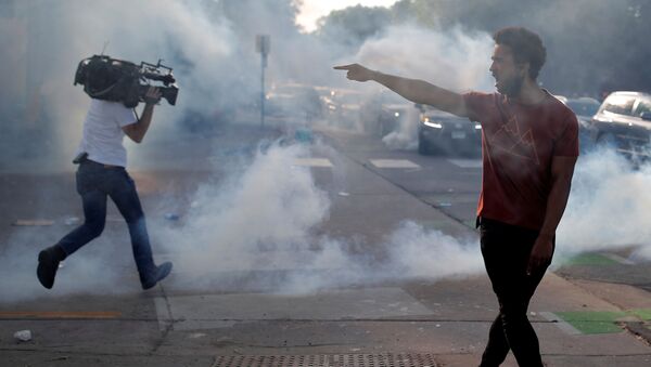 Demonstrant sa policijskim službenicima dok novinar beži od suzavaca tokom demonstracije zbofroamerikanca Džordža Flojda u Mineapolisu - Sputnik Srbija