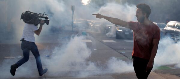 Демонстрант са полицијским службеницима док новинар бежи од сузаваца током демонстрације збофроамериканца Џорџа Флојда у Минеаполису - Sputnik Србија