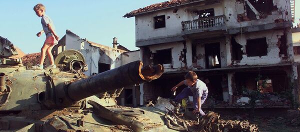 Deca se igraju na uništenom tenku u Klini tokom bombardovanja 1999. godine - Sputnik Srbija