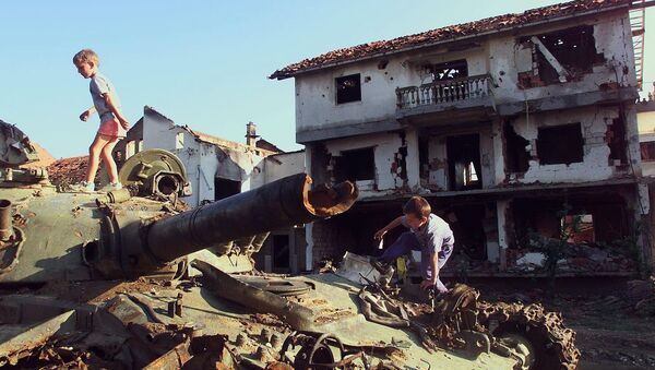 Deca se igraju na uništenom tenku u Klini tokom bombardovanja 1999. godine - Sputnik Srbija