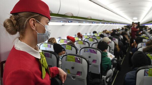 Стјуардеса са маском у авиону током лета - Sputnik Србија
