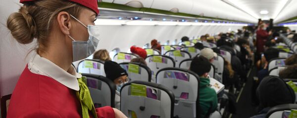 Stjuardesa sa maskom u avionu tokom leta - Sputnik Srbija