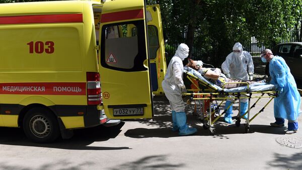 Лекари хитне помоћи уносе  у возило пацијента са сумњом на вирус корона - Sputnik Србија