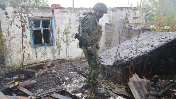 Pripadnik Narodne milicije Donjecke Narodne Republike (DNR) pored uništene kuće nakon što su ukrajinske snage granatirale mesto Gorlovku - Sputnik Srbija