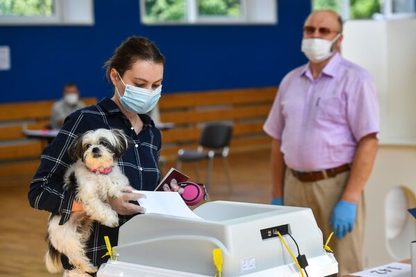 Devojka sa psom glasa na izborima o izmenama i dopunama Ustava Rusije na biračkom mestu u Moskvi. - Sputnik Srbija
