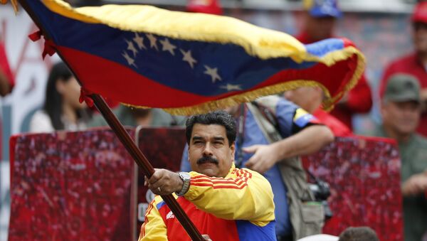 Президент Венесуэлы Николас Мадуро с национальным флагом во время демонстрации в Каракасе - Sputnik Србија