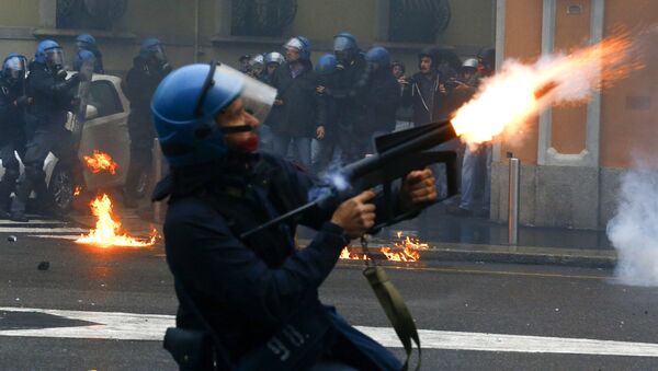 Policjac ispaljuje suzavac na proestima protiv EKSPO u Milanu , 1. maja 2015 - Sputnik Srbija