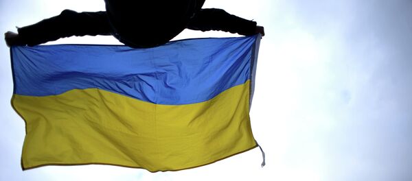 Čovek maše Ukrajinkom zastavom na trgu Majdan u Kijevu - Sputnik Srbija