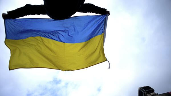 Čovek maše Ukrajinkom zastavom na trgu Majdan u Kijevu - Sputnik Srbija