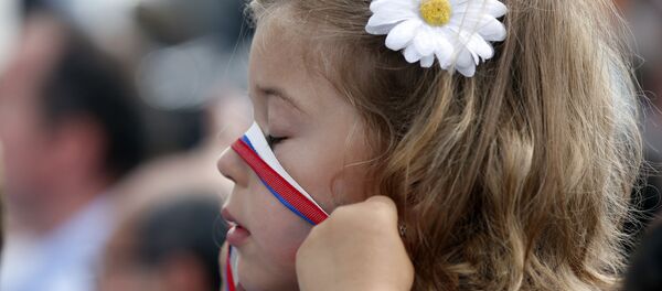 Девојка се игра са траком у бојама Руске заставе док чека да види руског председника Владимира Путина у Милану, Италија Девојка се игра са траком у бојама Руске заставе док чека да види руског председника Владимира Путина у Милану, Италија - Sputnik Србија
