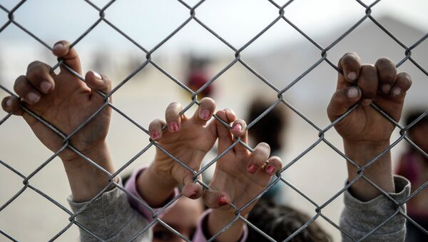 Deca sirijskih Kurda drže se za ogradu u izbegličkom kampu - Sputnik Srbija