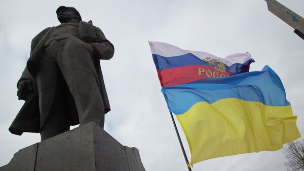 Zastave Ukrajine i Rusije pored spomenika Vladimira Iljiča Lenjina, u Donjecku, istočnoj Ukrajini - Sputnik Srbija