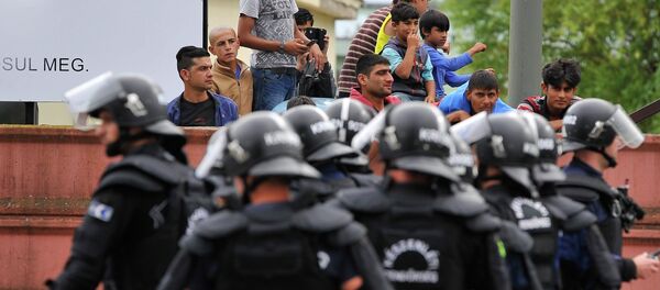 Полиција  стоји на улазу у  избеглички камп у Дебрецину, 230 километара од Будимпеште, Мађарска, понедељак, 29. јуна, 2015. - Sputnik Србија