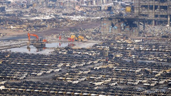 Rescuers walk next to damaged vehicles at the site of Wednesday night's explosions in Binhai new district of Tianjin, China, August 15, 2015 - Sputnik Srbija