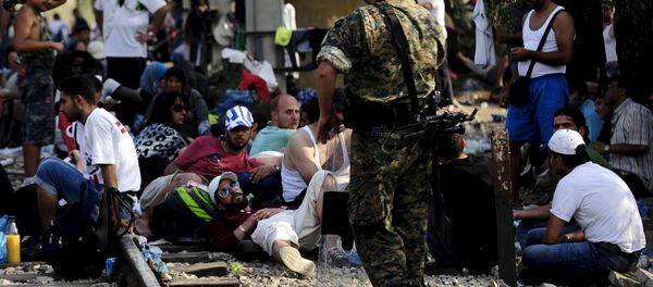 Македонски спецајлац стоји поред мигранта из Сирије у Ђевђелији, Македонија - Sputnik Србија