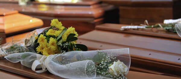 Cveće na kovčezima 13 migranata koji su bili među 800 poginulih u brodolomu koji se u aprilu dogodio u Kataniji - Sputnik Srbija