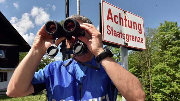 A policeman uses binoculars to secure the area on the Ederkanzel viewing platform near Mittenwald at the German-Austrian border on June 3, 2015 - Sputnik Србија