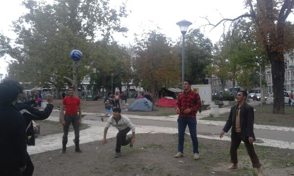 Мигранти из Авганистана лоптом коју су добили од Џоша играју одбојку у парку код Економског факултета - Sputnik Србија