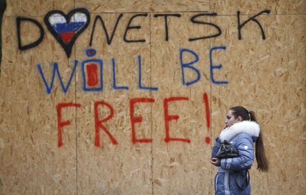Žena prolazi pored grafita „Donjeck će biti slobodan“ u Donjecku. - Sputnik Srbija