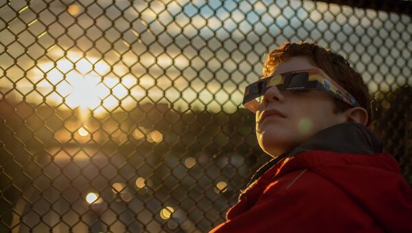 Дечак се спрема за посматрање помрачења сунца - Sputnik Србија