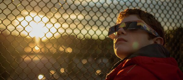 Dečak se sprema za posmatranje pomračenja sunca - Sputnik Srbija