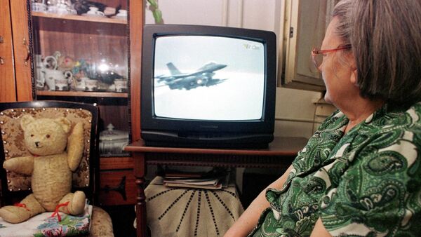 An unidentified Bosnian woman watches NATO air strikes against Yugoslav military targets on a TV screen in Tuzla, Bosnia, on Wednesday night, March 25, 1999. - Sputnik Србија
